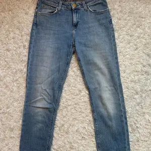 Blåa jeans i storlek waist 26 och längd 31. Finns en mindre skavank på byxornas baksida (se bild 3), annars är de i fint skick. De är ganska tajta i passformen och lite pösigare längst ner. Skriv för fler bilder eller funderingar🌸 100kr + frakt