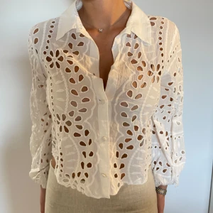Blus Zara - Vit blus från zara med knappar i fram, i nått slags virkat material. Så fin till sommaren!! Går lite längre än naveln. Är 164cm. Pris kan diskuteras vid snabb affär💓