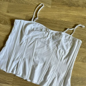 Topp från Prettylittlething  - I korsettmodell. Dragkedja baktill. Normal i storlek. En liten fläck på ena kupan som varit där sen jag köpte den tyvärr. 