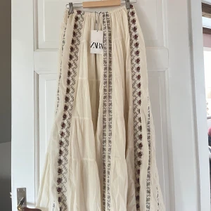 Vit lång kjol från Zara - Trendig och somrig lång kjol från Zara🌸 Helt ny skick och aldrig använd med prislapp kvar. Säljer på grund av ingen användning. 