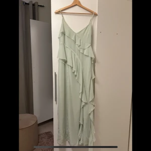 Frill chiffon Maxi dress - Jättefin ljusgrön klänning från Gina Tricot. Enbart använd vid ett tillfälle i någon timme. I princip slutsåld, nypris 600kr. Något liten i storleken och passar 38 också. Justerbara axelband. Slits fram