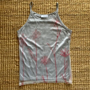 Grå linne från INXS - Silvrigt/metallic linne från INXS med tunna axelband och ett blommigt mönster i rött. Står M men känns mer som en XS/S 🎀
