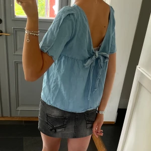 Blå topp från Massimo Dutti - Blå topp med öppen rygg och knytning frpn Massimo Dutti. Fint skick. Storlek 38, passar S och M. Använd gärna köp nu!