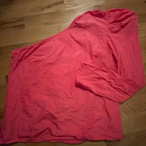 One-shoulder topp - Rosa one-shoulder topp med puffärm. Luftig passform. Använd en gång, dvs. i mycket fint skick.