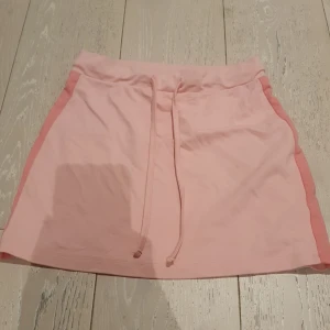 En rosa kjol med ljus rosa med mörkare rosa på sidorna. - Storlek XS.
