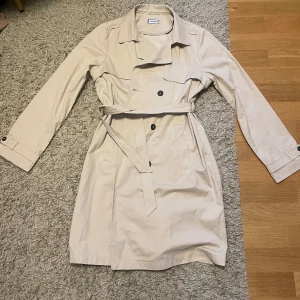 Trenchcoat  - Jackan är använd fåtal gånger och det finns inga fläckar