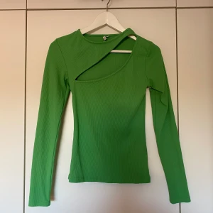 Grön tröja - Festligt grön tröja med utskärning vid bröstet. Storlek S från Nelly, aldrig använt. Tight i modellen så skulle säga att den passar som XS också