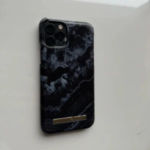 Ideal of Sweden iPhone skal - Använt skal från ideal of Sweden, passar iPhone 11 Pro/X/XS. Det är lite sönder vid kanten men det fungerar att använda som ni ser på bilden. Säljs pga ny mobil, säljer flera skal. 