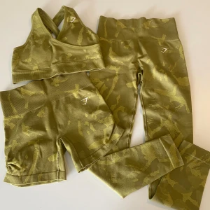 Gymshark Camo-set  - Ett gymset bestående av tights, topp och shorts i militärmönster. Tights och shorts har scrunch på baksidan. Använda ett fåtal gånger, men är som nyskick. Normal i storleken.