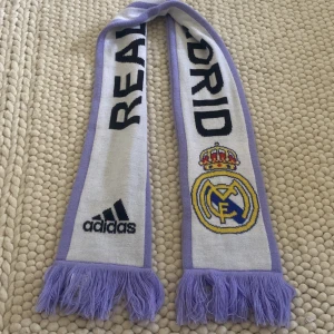 Real Madrid halsduk Champions League 21/22 - Jag säljer min Real Madrid halsduk som jag köpte i den officiella Champions League butiken i Paris under Champions League finalen 2022  Skick 10/10 änvänd en gång under Champions League finalen har bara hängt på väggen sen dess  Pris kan diskuteras 