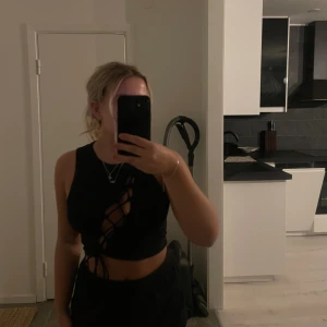 Svart topp - En svart fest topp från H&m men diagonal snörning.🩶