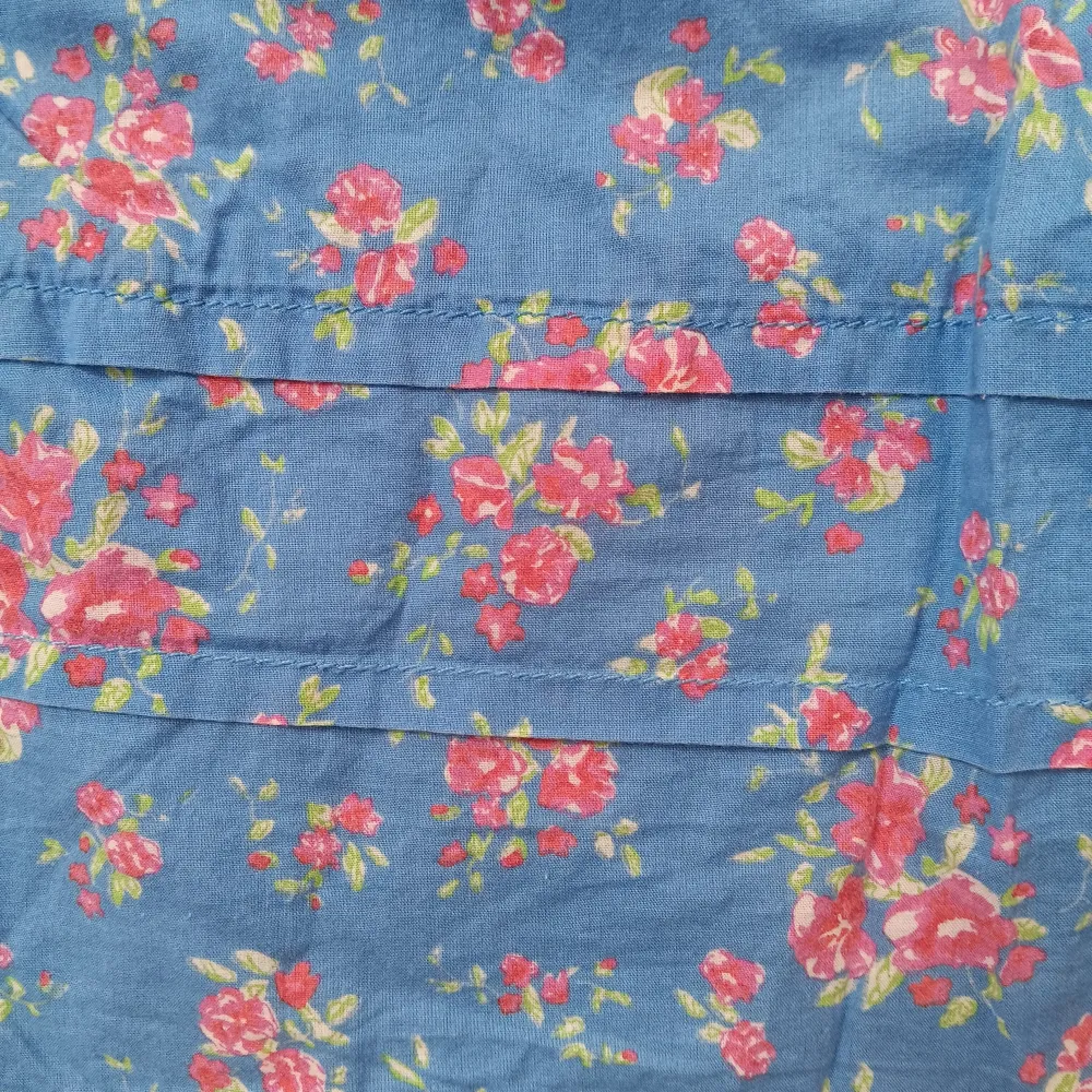 Blå klänning från H&M i blommigt mönster. Har en rosett band i midjan som kan jsutera storleken lite och fickor. Är i jättefint skick. Klänningar.