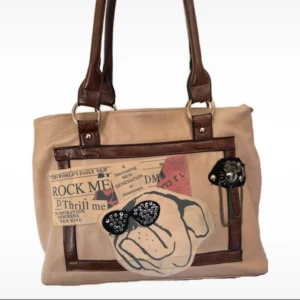 Häftig handväska  - handväska med så coolt motiv/tryck på framsidan! har ett tillhörande längre axelband också som går att ta av o sätta på. några mindre slitage (se bilder) men inget man tänker på o syns inte vid användning  bredd ca 32cm djup ca 14cm höjd ca 26cm