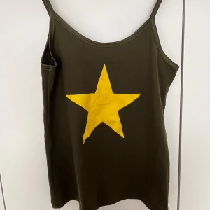 Stjärnlinne - Superfint militärgrönt linne med en gul stjärna framtill! ⭐️ microfläck i mitten av stjärnan men ingenting jag upplever syns tydligt. Hör av er vid frågor ❤️ 