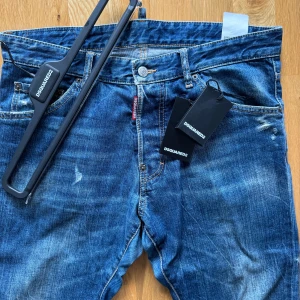 Ds2- Dsquared2 jeans  - Väldigt stilrent och snyggt par jeans av märke ds2. Skicket är otroligt bra och endast använda ett fåtal gånger. Nypris när de köptes var 2100kr. Plagget är i storlek 50 (italiensk storlek) passar 30-32 i vanliga jeansstorlekar. Extra knappar medfölj