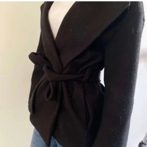 Kort kappa - Säljer denna svarta korta kappan med band i jättebra skick. Köpte här på plick för 230kr men måste sälja igen då den inte riktigt passade på mig. Har lånat bilder från tidigare säljare💕💕