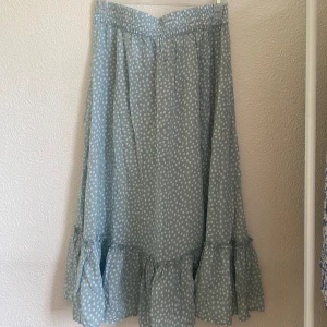 Grön midikjol - Grön prickig midikjol köpt från Only. Den är i nyskick utan prislapp och är i storlek XS. Den har volanger längst ner💗