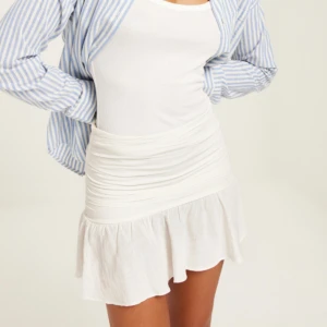 Linnekjol - Säljer denna vita linnekjolen från Nelly i storlek XS. Den är tyvärr för liten för mig så kan inte visa den på och den är därför heller aldrig använd🤍