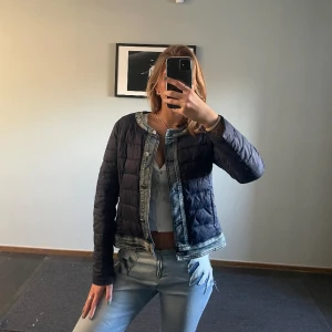 Dunjacka med denim detaljer - Så himla snygg dunjacka som är perfekt nu till våren med svin snygga denimdetaljer runt om. Köpt second hand och använd en gång. Inga defekter. Storlek M och jag brukar ha S i jackor. 
