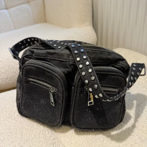Noella bag - Säljer nu min väl använda svarta glittriga noella väska.  Använt skick, man får med band till den också  Köpt för 699kr Mitt pris 150kr