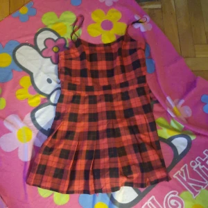 Röd rutig divided schoolgirl klänning  - Storlek; 44 l (Dragkedjan är igensydd så man får trä den över huvudet)