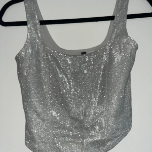Glittertopp - Supersöt glittrig topp ifrån hm.  Aldrig använd  Är normal i storleken men glittrar av sig lite Perfekt till fest