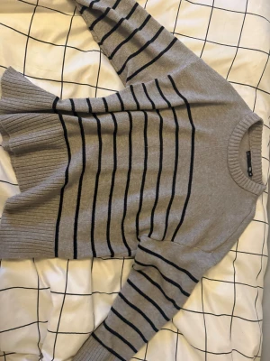 Grå randig stickad tröja från lager 157 storlek XS - Grå stickad tröja från 157 i storlek XS med svarta horisontella ränder. Tröjan har rund hals, långa ärmar.en lite vit fläck på ärmen som går att tvätta bort skriv ifall ni vill ha mer bilder eller något annat,säljer eftersom den inte är riktigt min stil längre 