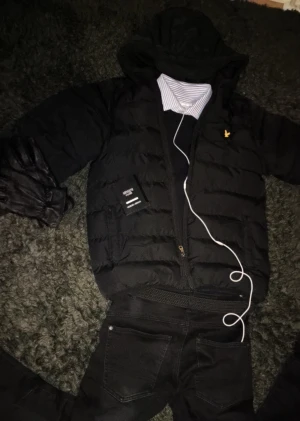 Svart pufferjacka från Lyle & Scott - Svart pufferjacka från Lyle & Scott! Perfekt för kalla dagar och riktigt snygg och enkelt att styla! Jackan har inga defekter och är använd ett fåtal gånger. Jackan passar S/M