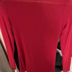 Röd långärmad topp - Säljer en snygg röd långärmad topp i ett mjukt och stretchigt material. Perfekt för både vardag och fest! Toppen har en tight passform som framhäver figuren. Den är enkel men stilren och kan matchas med nästan vad som helst. Passa på att köpa denna mångsidiga topp! ❤️