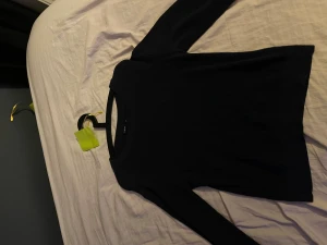 Svart ribbad tröja från LMTD - En svart långärmad tröja från LMTD i ribbat material. Tröjan har en rund halsringning och är figurnära i modellen, perfekt att styla med jeans eller kjol. Enkel och stilren design som funkar till många olika looks.