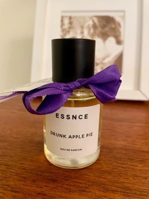 Drunk Apple Pie eau de parfum Essnce - Hej! Jag säljer denna parfym från Essnce - Drunk Apple Pie som jag köpte på pop-up butiken i Stockholm hösten 2025. Den har förvarats mörkt och svalt i min klädkammare och jag har tagit enstaka sprayningar. Etiketten med bandet har jag skrivit för jag gillar att se noterna på parfymerna och det ingår förstås.  Toppnoter är Konjak& Kaffe. Hjärtnoter är Kanel, Tonkaböna & Ekträ Basnoter är Pralin, Vanilj & Sandelträ.   Parfymen är inspirerad av Kilian Angels Share. 