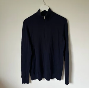 Mörkblå polotröja Selected Homme - Snygg mörkblå polotröja från Selected Homme med half zip-dragkedja framtill. Tröjan har lång ärm och är tillverkad i mjuk bomull, perfekt för dig som gillar stilrena och enkla plagg. Passar dig som vill ha en clean look med lite edge. 4Ö17