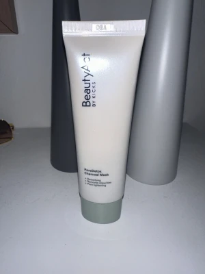 BeautyAct PoreDetox Charcoal Mask - PoreDetox Charcoal Mask från BeautyAct by Kicks är en ansiktsmask med kol som detoxar huden, minskar synliga porer och tar bort orenheter. Tuben är vit med grått lock och rymmer 50 ml. Innehåller vitamin B6 och pepparmyntsolja för en fräsch känsla. Ej plomberad men oanvänd