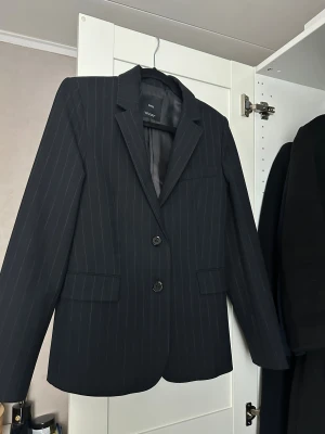 Randig kavaj från Mango - Väldigt, väldigt mörkblå randig kavaj från Mango i storlek XS, passar även S. Använd två gånger. 