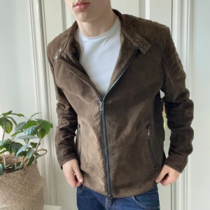 Rare Hugo boss mocka jacka  - Hugo boss jacka, väldigt rare Hugo boss jacka som är liksom mocka matieral. Vet ej till tusen procent om det är exakt mocka dock. Kolla gärna taggen, tror man kan hitta exakta modellen så kan man få reda på fler detaljer om jackan. Den är väldigt skön och sitter najs med dubbel kedjad och en väldigt najs logga på ärmen. Modellen är 180 cm 75 kg och bär L. Kom med frågor!