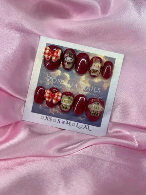 RedLeo (M);ExtraShortOval  - Handgjorda press-on naglar i vinrött med glitter, dekorerade med 3D rosetter i rött och vitt samt söta sanriomotic med leopardkläder. Extra kortaovala och glansiga, perfekta för dig som vill ha något unikt och gulligt på naglarna.M: 16 mm, 12 mm, 12,5 mm, 11,5 mm, 10 mm 