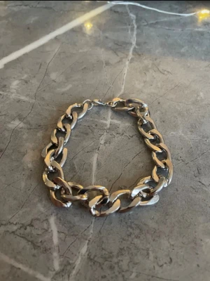 Silverfärgat armband - Ett stilrent silverfärgat armband med en något kraftigare design som ger ett exklusivt och självsäkert intryck. Den 20 cm långa passformen sitter bekvämt runt handleden och passar lika bra till vardag som fest. En tidlös detalj som lyfter varje outfit.⭐️