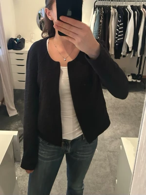 Svart quiltad kofta  - Säljer en svart quiltad kofta med dragkedja framtill. Koftan har rund halsringning, fickor, lång ärm och en lätt strukturerad yta. 