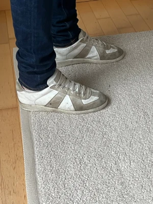 Maison margiela skor i vit färg - Tjena säljer ett par maison skor som passar perfekt för dig som vill ha en mer klassisk stil. Storlek är 39,5 men passar 40/41