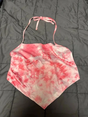 Rosa och vit bandana topp från SHEIN - Säljer en snygg bandana topp från SHEIN i storlek M. Toppen har ett rosa och vitt batikmönster, tunna axelband som knyts i nacken och baktill, samt en spetsig nederkant. Materialet är mjukt och stretchigt
