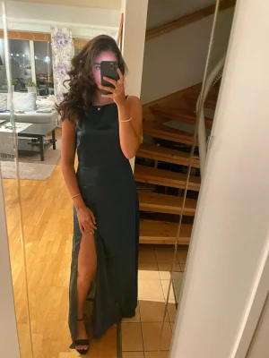 Mörkgrön balklänning!💕 - Säljer min mörkgröna balklänning med slits på ena sidan!💕Endast använd 1 gång! Klänningen är ärmlös med öppen rygg och en figurnära passform. Perfekt för bal eller festliga tillfällen! Nypris: 1200kr