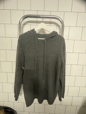 Mörkgrå Kashmir Hoodie - En stilren och enkel Kashmir hoodie som är använd fåtal gånger. Mörkgrå färg som passar till det mesta. Hör av dig vid intresse