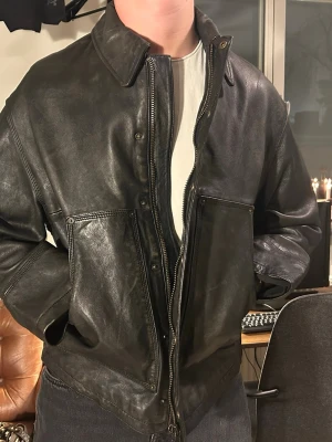 Vintage skinnjacka - Säljer en svart skinnjacka från zara i äkta läder med vintagekänsla.                                      Storlek 48 (typ medium)och den passar lite ”boxy”. Helt ny lappar kvar