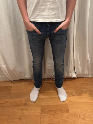 Jack&Jones mörkblå jeans - Säljer ett par Jack&Jones jeans i mörkblå tvätt. De har en slim passform med raka ben och klassiska fem fickor. Jeansen är tillverkade i slitstarkt denim och har snygga kontrastsömmar. Perfekta för dig som gillar en clean och tidlös look. Storleken är 27/30