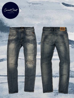 Replay Anbass blå jeans, storlek 29/32 - Säljer ett par Replay Anbass jeans i blå tvätt med slitningar och patchdetaljer på benen. Klassisk femficksmodell med raka ben och snyggt slitna detaljer för en avslappnad look. Tillverkade i mjukt jeansmaterial som sitter skönt hela dagen. Slitningen går igenom byxan.