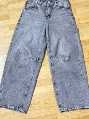Grå wide jeans från H&M Divided - Säljer ett par grå tvättade jeans från H&M Divided i storlek 38. De har en loose och wide passform med raka ben och klassiska fem fickor. Jeansen har hög midja och är tillverkade i ett slitstarkt bomullsmaterial. Ska tvättas innan den skickas. Ni får gärna skriva till om ni behöver fler bilder ☺️Priset går att diskutera 
