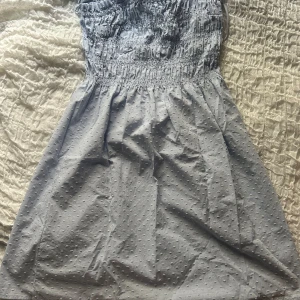 Ljusblå kort klänning från H&M  - Supersöt ljusblå kort klänning från H&M med smockad överdel och tunna axelband som knyts upptill. Den har inga lappar kvar men aldrig använd❣️