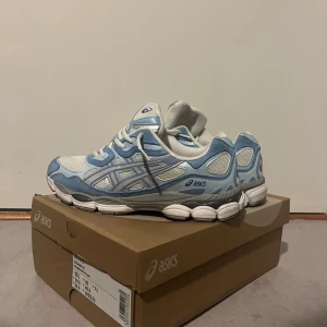 Asics gel nyc - Säljer ett par fräscha ASICS sneakers i ljusblått och vitt med grå detaljer. Skorna har meshpaneler för extra andningsförmåga, riktigt snygga och passar fint till allt. Priset kan diskuteras.