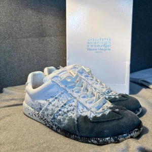 Maison Margiella paint splatter - Säljer ett par feta Maison Margiella paint splatter i storlek 42. Skorna är sparsamt använda och sitter bra. Allt på bilderna medföljer. Tveka inte att skriva för frågor!