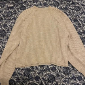 Beige stickad tröja med rund hals - Beige mjuk stickad tröja med rund hals och långa ärmar. Ribbad. Strl S och kan passa som Xs och M. 